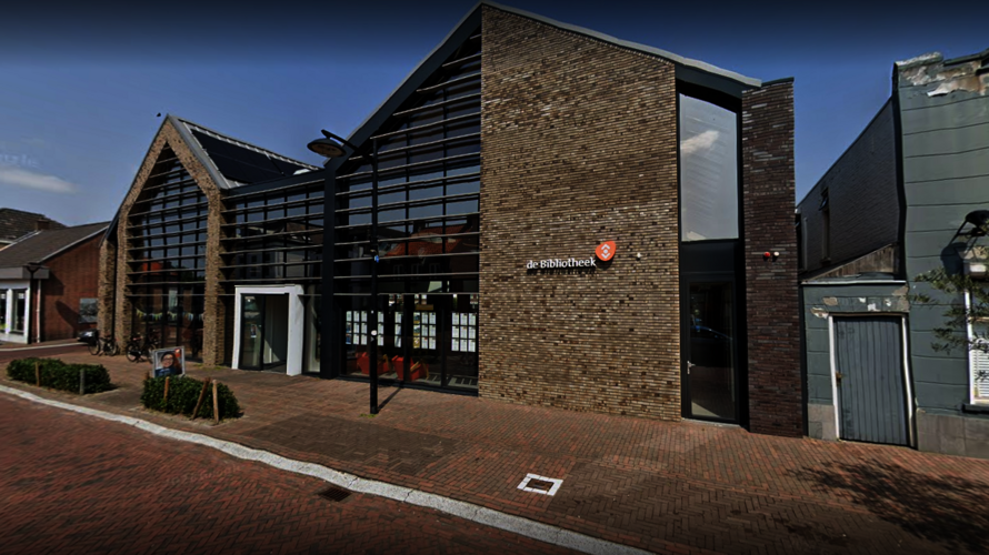 Modern bibliotheekgebouw in Raamsdonksveer met grote glazen ramen en bakstenen muren, met het bord “de Bibliotheek” bij de ingang.