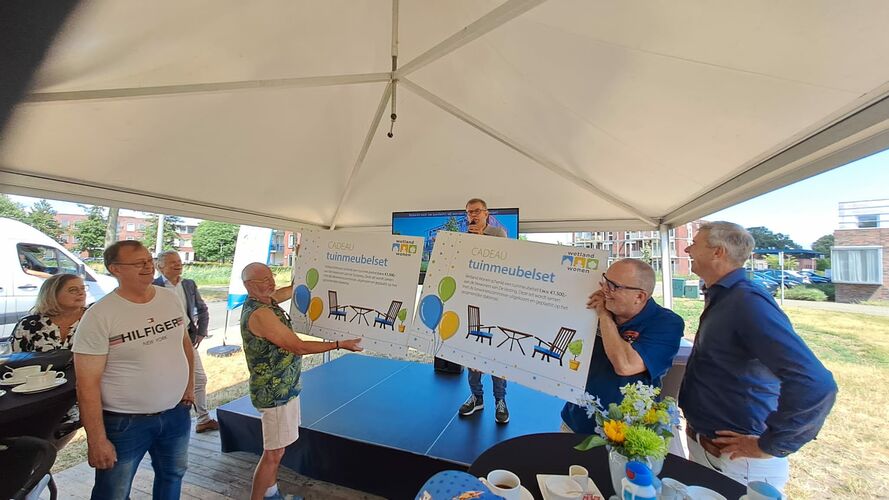 Leden van de bewonerscommissies van de Sluisweg en De Vesting nemen de cheque voor een tuinset in ontvangst van Wetland Wonen