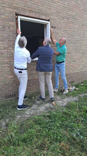 Marcel Timmerman, directeur-bestuurder van Wetland Wonen en Wethouders Jan van der Poel en Harrie Rietman van gemeente Zwartewaterland halen een kozijn uit een van de te slopen woningen. Dit hout wordt hergebruikt.