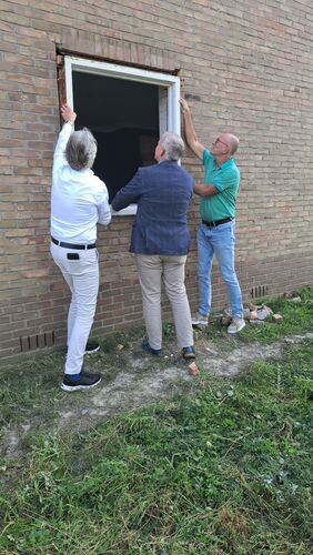 Marcel Timmerman, directeur-bestuurder van Wetland Wonen en Wethouders Jan van der Poel en Harrie Rietman van gemeente Zwartewaterland halen een kozijn uit een van de te slopen woningen. Dit hout wordt hergebruikt.