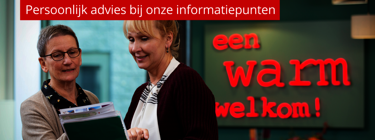 Twee medewerkers van Wooninc. die samen in gesprek zijn in het loket bij SeniorenPunt.