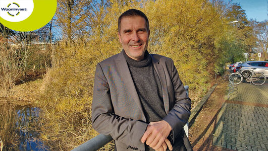 Bestuurder Peter van Heeswijk poseert voor het kantoorgebouw.