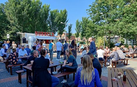Medewerkers tijdens een borrel voor het kantoorgebouw.