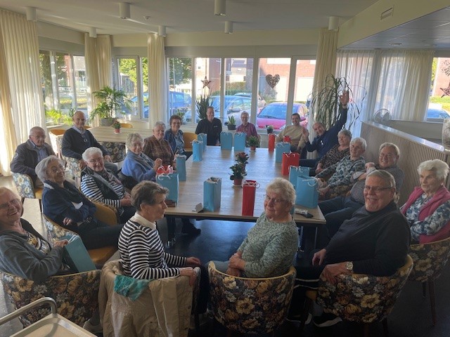 Foto van een groep vrijwilligers, zittend rond de tafel