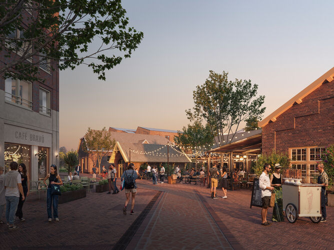 Gezellige straat in het Kazernekwartier tijdens zonsondergang, met sfeerverlichting en het Bravo complex zichtbaar tussen het groen.